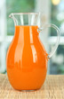 Orange juice in pitcher on table in room