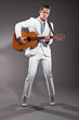 Retro rock and roll male guitar player wearing white suit. Studi