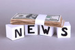 White paper cubes labeled "News" with money on grey background