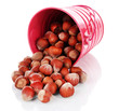 Overturned bucket with hazelnuts isolated on white