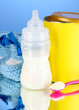 Bottle with milk and food for babies on blue background