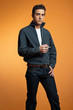 Retro fifties fashion man smoking cigarette. Studio shot. Orange