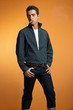 Retro fifties fashion man smoking cigarette. Studio shot. Orange