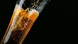 Beer pouring into glass on black background