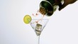 Hand pouring cocktail into glass from cocktail shaker
