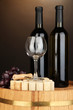 Wine and corks on barrel on brown background