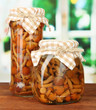 Delicious marinated mushrooms in glass jars,