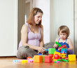 pregnant mother plays with child in home