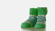 Green slippers falling on a white surface