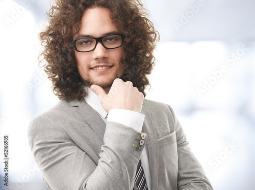 Photo: Portrait of a young businessman who's standing in his office Portrait of a young businessman who's standing in his office