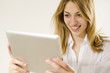 smiling girl holding and looking at her tablet