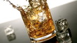 Ice falling into tumbler of whiskey and ice 