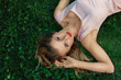 Foto: Young woman lying on grass Young woman lying on grass
