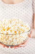 Girl holding a glass bowl of popcorn
