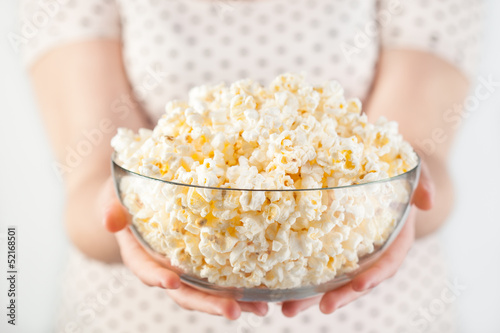 Photo: Girl holding a glass bowl of popcorn Girl holding a glass bowl of popcorn