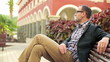Young happy man relaxing on bench in the city