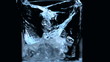 Two ice cubes falling into glass on black background