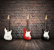 Drei E-Gitarren an Backsteinmauer