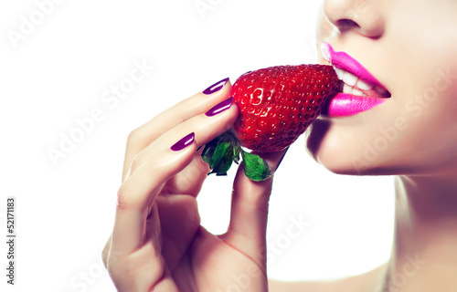 Photo: Woman Biting Strawberry.purple manicure Woman Biting Strawberry.purple manicure