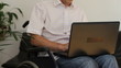 Businessman in wheelchair working on laptop computer