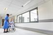 Senior Female Patient in Wheelchair & Nurse in Hospital