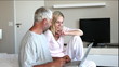 Couple using laptop together in the bedroom