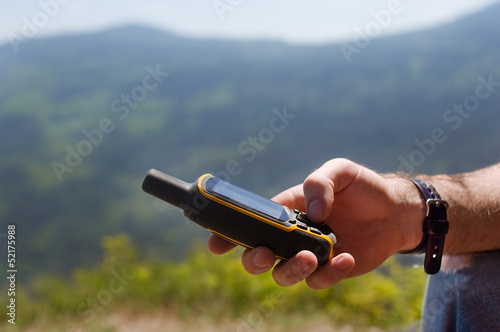 Photo: Man holding in his hand GPS Man holding in his hand GPS