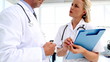 Doctors discussing and writing on a folder