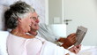 Mature couple solving crossword in the bed