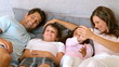 Happy family lying in a bed