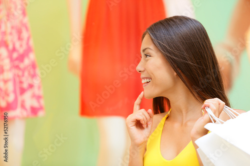 Photo: Shopping woman looking at window display at store Shopping woman looking at window display at store