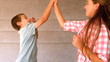 Siblings high-fiving in bedroom