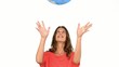 Woman throwing a globe in the air on white background