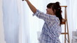 Vídeo: Attractive woman jumping to paint her wall in blue Attractive woman jumping to paint her wall in blue