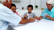 Grandparents playing cards with their grandchildren at home