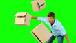 Clumsy man dropping boxes down on green screen