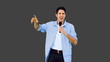 Man singing into microphone and dancing on grey background