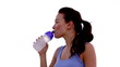 Woman drinking water on the beach and smiling at camera