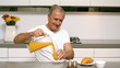 Video: Retired man pouring orange juice for breakfast Retired man pouring orange juice for breakfast