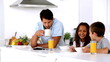 Father having breakfast with his children and drinking coffee