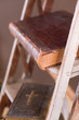 Old books on aged white ladder