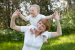 smiling mother holding a child on his shoulders