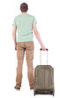Photo: Back view of man with green suitcase looking up Back view of man with green suitcase looking up