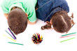 Top view of two children drawing with colorful crayons, isolated