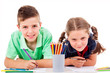 Photo: Two children draw with colorful crayons and smile, isolated over Two children draw with colorful crayons and smile, isolated over