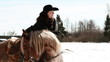 girl cowboy sitting on a horse in winter