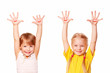 Photo: Two little girls raising their hands up. Young students Two little girls raising their hands up. Young students