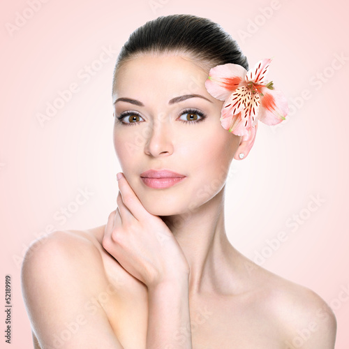 Photo: Beautiful woman with clean face and flower Beautiful woman with clean face and flower