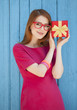 Photo: redhead girl in glasses with gift near wood background redhead girl in glasses with gift near wood background