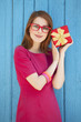 Photo: redhead girl in glasses with gift near wood background redhead girl in glasses with gift near wood background